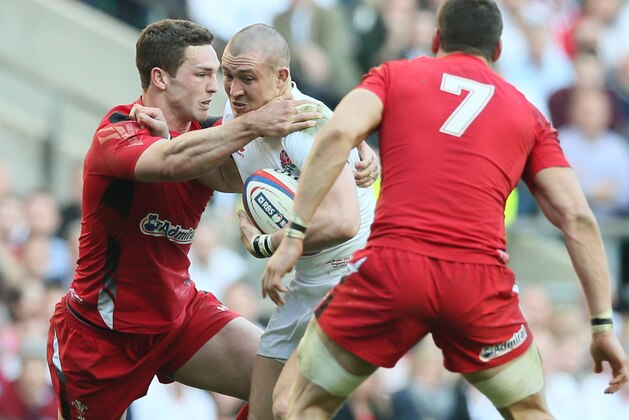England's Mike Brown, center, is tackled by Wales' George North during the Six Nations Rugby Union match between England and Wales at Twickenham stadium in London Sunday March 9, 2014. (AP Photo/Alastair Grant)