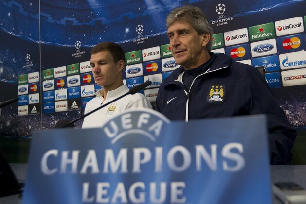 Manchester City's manager Manuel Pellegrini, right, sits alongside Edin Dzeko during a press conference at the Etihad Stadium, Manchester, England, Tuesday Oct. 1, 2013. Manchester City will play Bayern Munich on Wednesday in a Champions League Group D soccer match. (AP Photo/Jon Super)