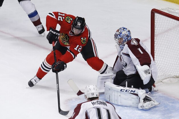 Colorado Avalanche goalie Semyon Varlamov (1) makes a save on a shot by Chicago Blackhawks center Peter Regin (12) as Avalanche's  Jamie McGinn (11) watches during the second period of an NHL hockey game Tuesday, March 4, 2014, in Chicago. (AP Photo/Charles Rex Arbogast)