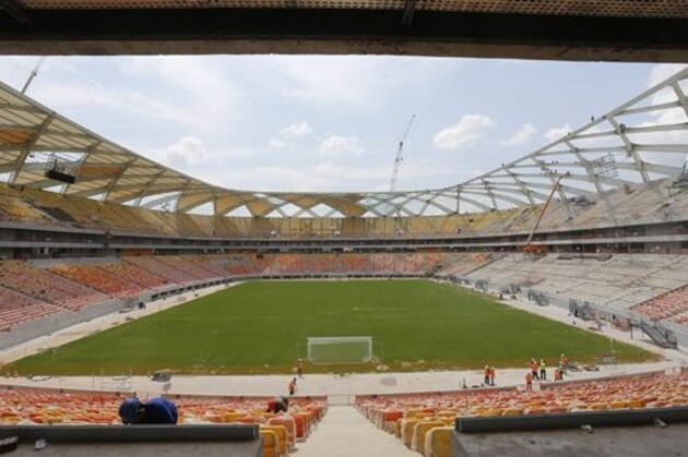 FILE - This is a Tuesday, Dec. 10, 2013  file photo workers erect the roof of the Arena Amazonia in Manaus, Brazil.  Manaus is the most remote of Brazil’s World Cup cities. Of all places visited by the World Cup in 84 years of traveling the globe, the Amazon city of Manaus is arguably the most wild and wacky, a new frontier for football’s showcase. (AP Photo/Ferdinand Ostrop, File)