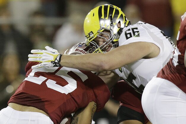 Oregon defensive tackle Taylor Hart (66) tackles Stanford running back Tyler Gaffney (25) during an NCAA college football game in Stanford, Calif., Thursday, Nov. 7, 2013. (AP Photo/Jeff Chiu)