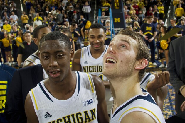 Michigan guard Caris LeVert, left, and guard Nik Stauskas, right, celebrate with their teammates after an NCAA college basketball game against Indiana at Crisler Center in Ann Arbor, Mich., Saturday, March 8, 2014. Michigan won 84-80, and celebrated their outright Big Ten regular season championship. (AP Photo/Tony Ding)
