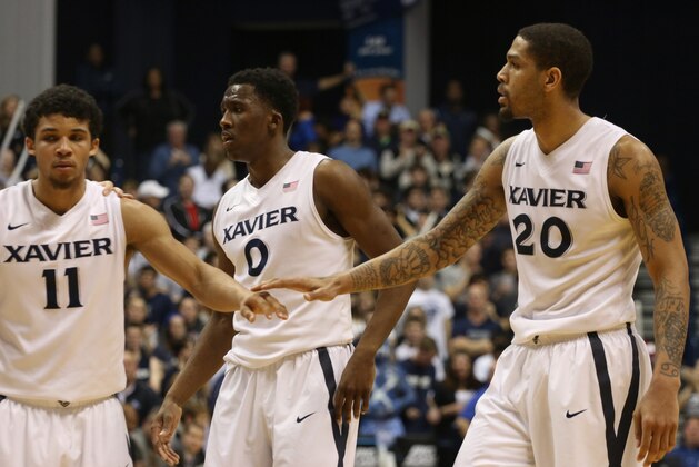 Xavier's Dee Davis, Semaj Christon, and Justin Martin, lef to right, congratulate each other near the end of the game with Creighton in the second half of their NCAA college basketball game at Xavier University in Cincinnati Saturday March 1, 2014. Xavier won 75-69. (AP Photo/Tom Uhlman)