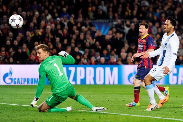 BARCELONA, SPAIN - MARCH 12:  Lionel Messi of Barcelona flicks the ball past goalkeeper Joe Hart of Manchester City to score the opening goal during the UEFA Champions League Round of 16, second leg match between FC Barcelona and Manchester City  at Camp Nou on March 12, 2014 in Barcelona, Spain.  (Photo by David Ramos/Getty Images)