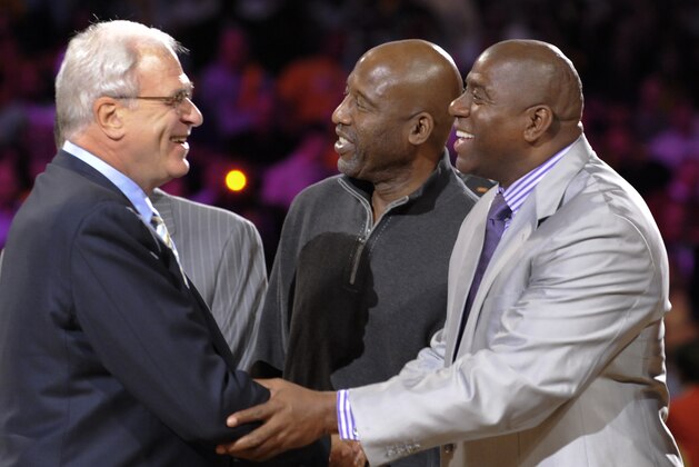 FILE - In this Oct. 27, 2009, file photo, Los Angeles Lakers coach Phil Jackson, left, shakes hands with former Laker Magic Johnson, right, before an NBA basketball game in Los Angeles. Johnson sold his small ownership stake in the Lakers to Dr. Patrick Soon-Shiong on Monday, Oct. 18, 2010. Johnson bought shares representing about 4.5 percent of the Lakers in June 1994 for a reported $10 million. Johnson said the sale was strictly a
