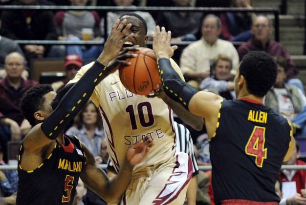 Jan 12, 2014; Tallahassee, FL, USA; Florida State Seminoles forward Okaro White (10) is fouled as he is defended by Maryland Terrapins guard Seth Allen (4) and guard Nick Faust (5) during the first half at Donald L. Tucker Center. Mandatory Credit: Melina Vastola-USA TODAY Sports