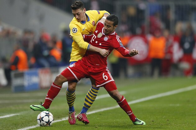Arsenal's Mesut Ozil, left, and Bayern's Thiago Alcantara challenge for the ball during the Champions League round of 16 second leg soccer match between FC Bayern Munich and FC Arsenal in Munich, Germany, Wednesday, March 12, 2014. (AP Photo/Matthias Schrader) Arsenal's Mesut Ozil, left, and Bayern's Thiago Alcantara challenge for the ball during the Champions League round of 16 second leg soccer match between FC Bayern Munich and FC Arsenal in Munich, Germany, Wednesday, March 12, 2014. (AP Photo/Matthias Schrader)