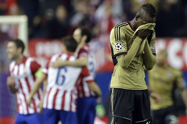 AC Milan's Mario Balotelli walks on the pitch as Atletico Madrid players celebrate in background, during a Champions League, round of 16, second leg, soccer match between Atletico Madrid and AC Milan at the Vicente Calderon stadium in Madrid, Tuesday March 11, 2014. (AP Photo/Paul White)