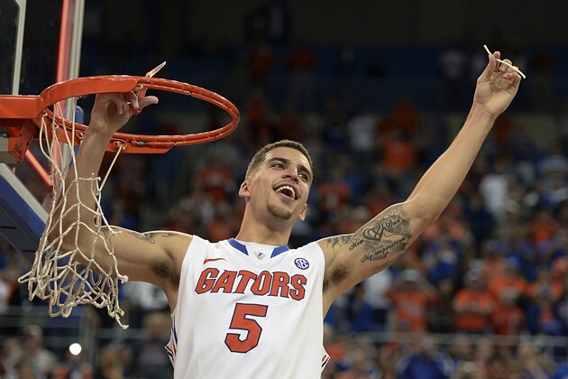 Florida guard Scottie Wilbekin (5) holds up a piece of the net after the Gators became the first team in Southeastern Conference history to go 18-0 in league pla, Saturday, March 8, 2014 in Gainesville, Fla.    Florida defeated Kentucky 84-65 Saturday in an NCAA college basketball game. (AP Photo/Phil Sandlin)