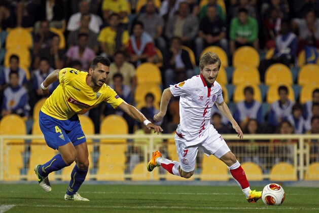 Sevilla's Marko Marin, from Germany, sidesteps Estoril's Bruno Miguel, left, during their Europa League group H soccer match at the António Coimbra da Mota stadium in Estoril, near Lisbon, Thursday, Sept. 19, 2013. (AP Photo/Francisco Seco)