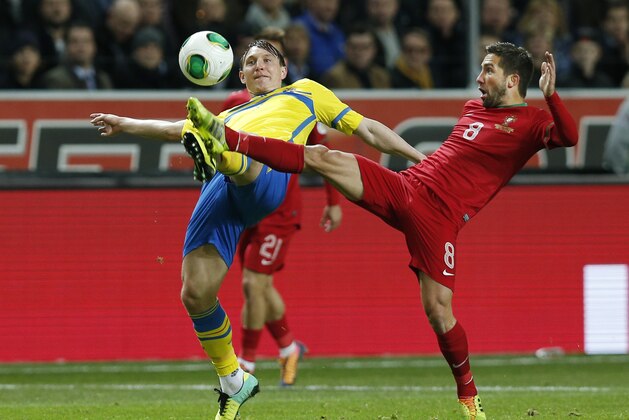 Sweden's Kim Kallstrom, left, and Portugal's Joao Moutinho challenge for the ball during the World Cup qualifying playoff second leg soccer match between Sweden and Portugal in Stockholm, Sweden, Tuesday, Nov.19, 2013. (AP Photo/Frank Augstein)