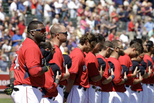 Boston Red Sox designated hitter David Ortiz, left, joins with his team in removing their caps during the playing of the national anthem before of an exhibition baseball game against the Minnesota Twins, Friday, Feb. 28, 2014, in Fort Myers, Fla. (AP Photo/Steven Senne)