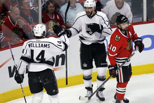 Los Angeles Kings center Dwight King (74) celebrates his goal with right wing Justin Williams (14) during the second period in Game 5 of the NHL hockey Stanley Cup playoffs Western Conference finals, Saturday, June 8, 2013, in Chicago. At right is Chicago Blackhawks center Patrick Sharp. (AP Photo/Charles Rex Arbogast)