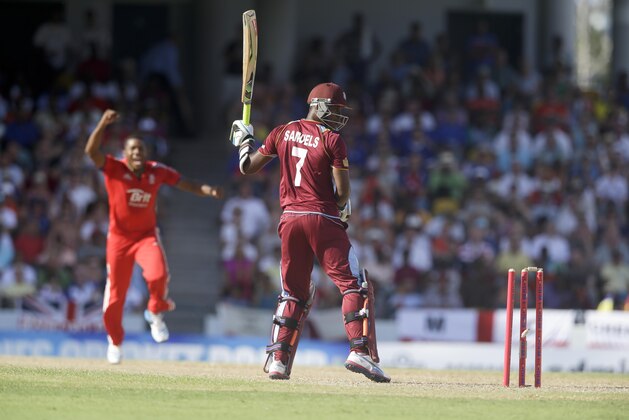 West Indies' Marlon Samuels looks at the wickets after he was bowled by England's Chris Jordan during their third T20 International cricket match at the Kensington Oval in Bridgetown, Barbados, Thursday, March 13, 2014. (AP Photo/Ricardo Mazalan)