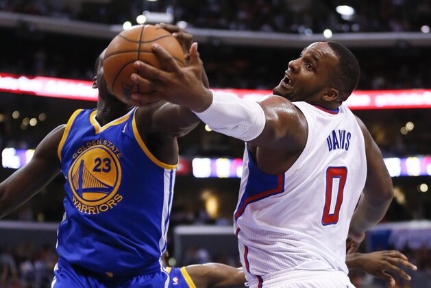 Los Angeles Clippers' Glen Davis, right, and Golden State Warriors' Draymond Green, left obstructed, reach for a rebound during the first half of an NBA basketball game in Los Angeles, Wednesday, March 12, 2014. (AP Photo/Danny Moloshok)