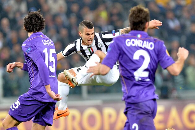 Juventus forward Sebastian Giovinco, center, is airborne as Fiorentina's Stefan Savic, left, and Gonzalo look at him, during an Europa League, round of 16, soccer match between Juventus and Fiorentina at the Juventus stadium, in Turin, Italy, Thursday, March 13, 2014. (AP Photo/Massimo Pinca)