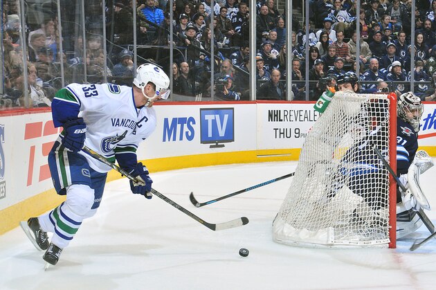 WINNIPEG, MB - MARCH 12: Goaltender Ondrej Pavelec #31 of the Winnipeg Jets keeps an eye on Henrik Sedin #33 of the Vancouver Canucks as he plays the puck behind the net during third period action at the MTS Centre on March 12, 2014 in Winnipeg, Manitoba, Canada. (Photo by Lance Thomson/NHLI via Getty Images)