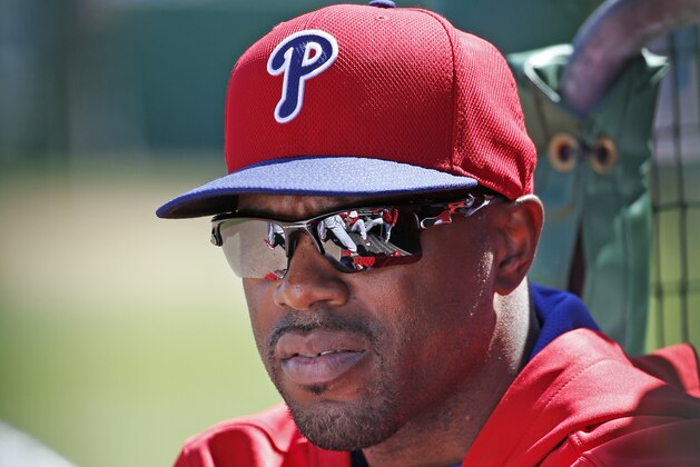 Philadelphia Phillies Jimmy Rollins sits in the dugout after not playing for the third consecutive game during a spring exhibition baseball game against the New York Yankees in Clearwater, Fla., Thursday, March 13, 2014.  Rollins said the situation was unusual; that he is healthy, therefore he is not sure why Phillies manager Ryne Sandberg is not playing him. (AP Photo/Kathy Willens)