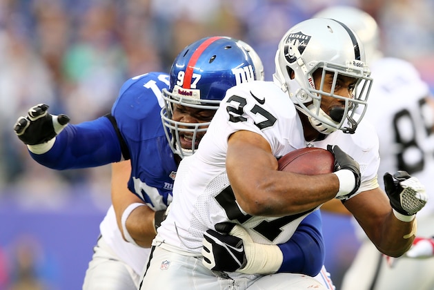 EAST RUTHERFORD, NJ - NOVEMBER 10:   Rashad Jennings #27 of the Oakland Raiders carries the ball as  Linval Joseph #97 of the New York Giants defends at MetLife Stadium on November 10, 2013 in East Rutherford, New Jersey.  (Photo by Elsa/Getty Images)