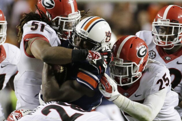Auburn wide receiver Sammie Coates (18) is stopped by Georgia safety Josh Harvey-Clemons (25), linebacker Ramik Wilson (51) and safety Tray Matthews (28) during the second half of an NCAA college football game in Auburn, Ala., Saturday, Nov. 16, 2013. Auburn beat Georgia 43-38. (AP Photo/Dave Martin)