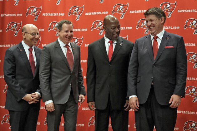 New Tampa Bay Buccaneers general manager Jason Licht laughs as he poses with from left, co-chairman Joel Glazer, co-chairman Bryan Glazer, and head coach Lovie Smith, during a news conference Thursday, Jan. 23, 2014, in Tampa, Fla. Licht becomes the fifth general manager in team history.  He takes over a team that hasn't made the playoffs since 2007. (AP Photo/Chris O'Meara)