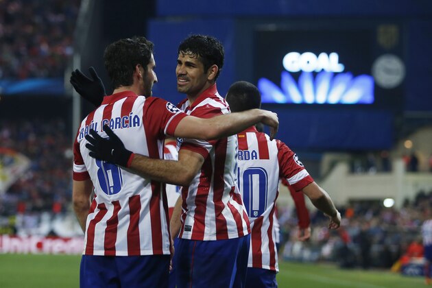 Atletico's Raul Garcia, left, celebrates his goal with Diego Costa, centre, during a Champions League last 16 second leg soccer match between Atletico Madrid and AC Milan, at the Vicente Calderon stadium in Madrid, Tuesday, March 11, 2014. (AP Photo/Andres Kudacki)