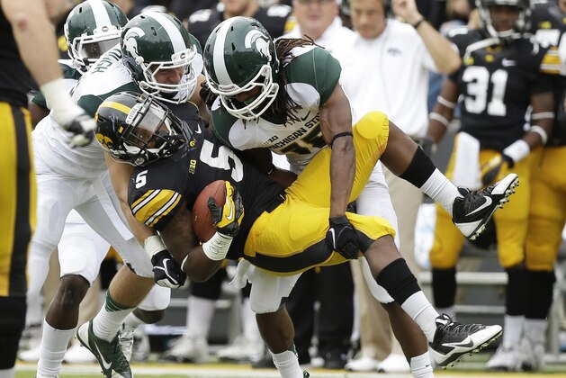 Iowa running back Damon Bullock, center, is tackled by Michigan State's Max Bullough, left, and Trae Waynes during the first half of an NCAA college football game, Saturday, Oct. 5, 2013, in Iowa City, Iowa. Michigan State won 26-14. (AP Photo/Charlie Neibergall)
