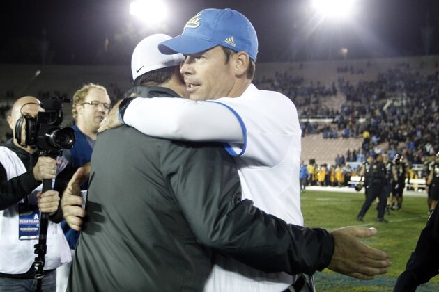 UCLA head coach Jim Mora hugs Washington head coach Steve Sarkisian after UCLA defeated Washington 41-31 in their NCAA college football game Friday, Nov. 15, 2013, in Pasadena, Calif.  (AP Photo/Alex Gallardo)