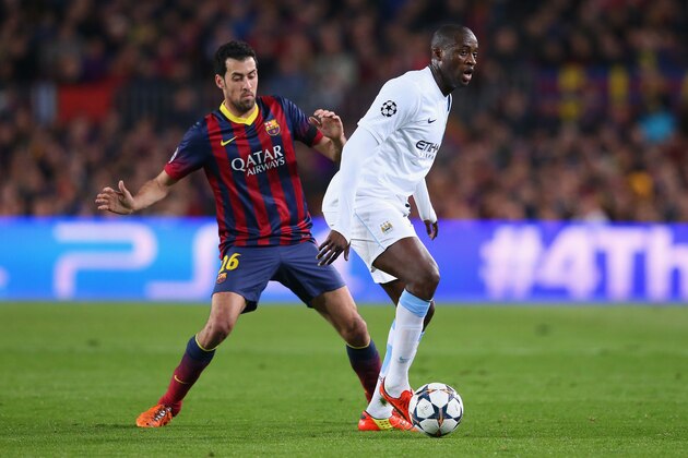 BARCELONA, SPAIN - MARCH 12:  Yaya Toure of Manchester City shields the ball from Sergio Busquets of FC Barcelona during the UEFA Champions League Round of 16 match between FC Barcelona and Manchester City at Camp Nou on March 12, 2014 in Barcelona, Spain.  (Photo by Alex Livesey/Getty Images)