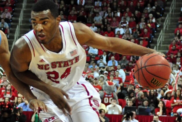 Feb 26, 2014; Raleigh, NC, USA; North Carolina State Wolfpack forward T.J. Warren (24) dribbles around North Carolina Tar Heels forward J.P. Tokoto (13) during the first half at PNC Arena.  Mandatory Credit: Rob Kinnan-USA TODAY Sports