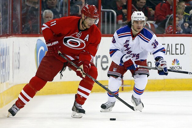 Carolina Hurricanes' Jordan Staal (11) moves the puck in front of New York Rangers' Mats Zuccarello (36) during the first period of an NHL hockey game in Raleigh, N.C., Tuesday, March 11, 2014. (AP Photo/Karl B DeBlaker)