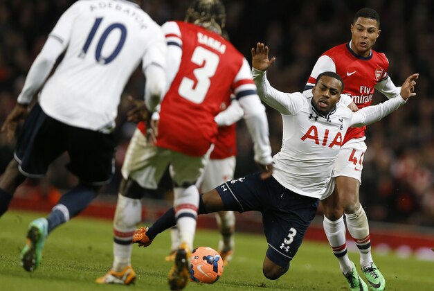Tottenham's Danny Rose, second right falls from the challenge of Arsenals' Serge Gnaby, right, during the English FA Cup third round soccer match between Arsenal and Tottenham Hotspur at the Emirates Stadium in London, Saturday, Jan. 4, 2014. (AP Photo/Kirsty Wigglesworth)