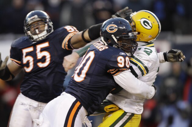 Chicago Bears defensive end Julius Peppers (90) hits Green Bay Packers quarterback Aaron Rodgers (12) as he passes the ball during the second half of the NFC Championship NFL football game Sunday, Jan. 23, 2011, in Chicago. Peppers was called for roughing the passer.  (AP Photo/David J. Phillip)