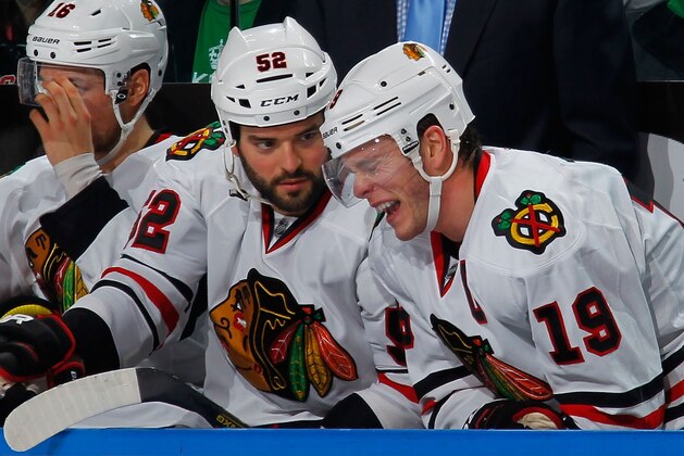 BUFFALO, NY - MARCH 09:  Jonathan Toews #19 of the Chicago Blackhawks winces in pain alongside Brandon Bollig #52 on the bench after being slashed on the arm in the third period against the Buffalo Sabres on March 9, 2014 at the First Niagara Center in Buffalo, New York. Toews returned to action and Chicago won, 2-1.  (Photo by Bill Wippert/NHLI via Getty Images)