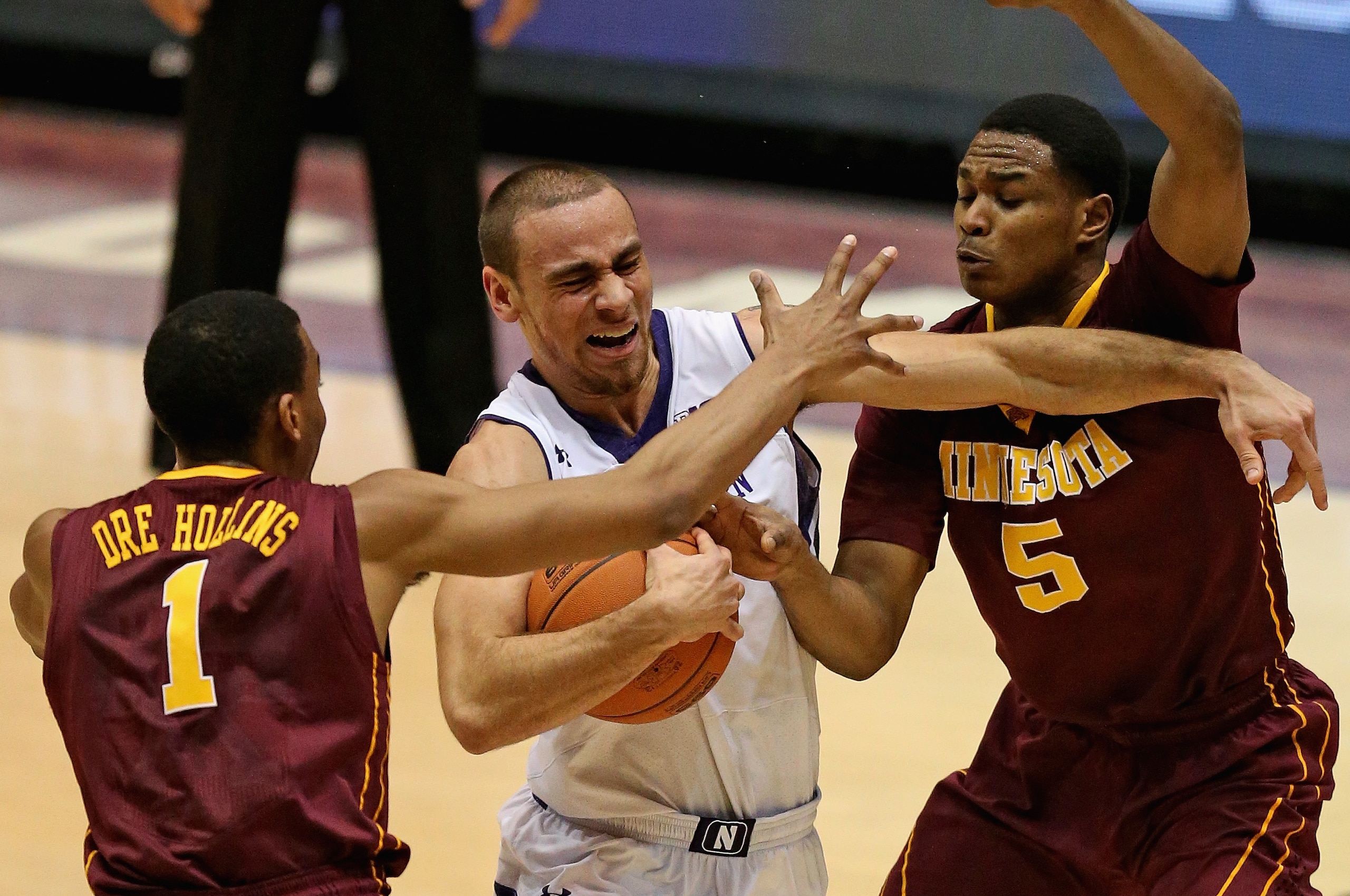 EVANSTON, IL - FEBRUARY 16:  Tre Demps #14 of the Northwestern Wildcats tries to drive between Andre Hollins #1 and Daquein McNeil #5 of the Minnesota Golden Gophers at Welsh-Ryan Arena on February 16, 2014 in Evanston, Illinois.  (Photo by Jonathan Daniel/Getty Images)