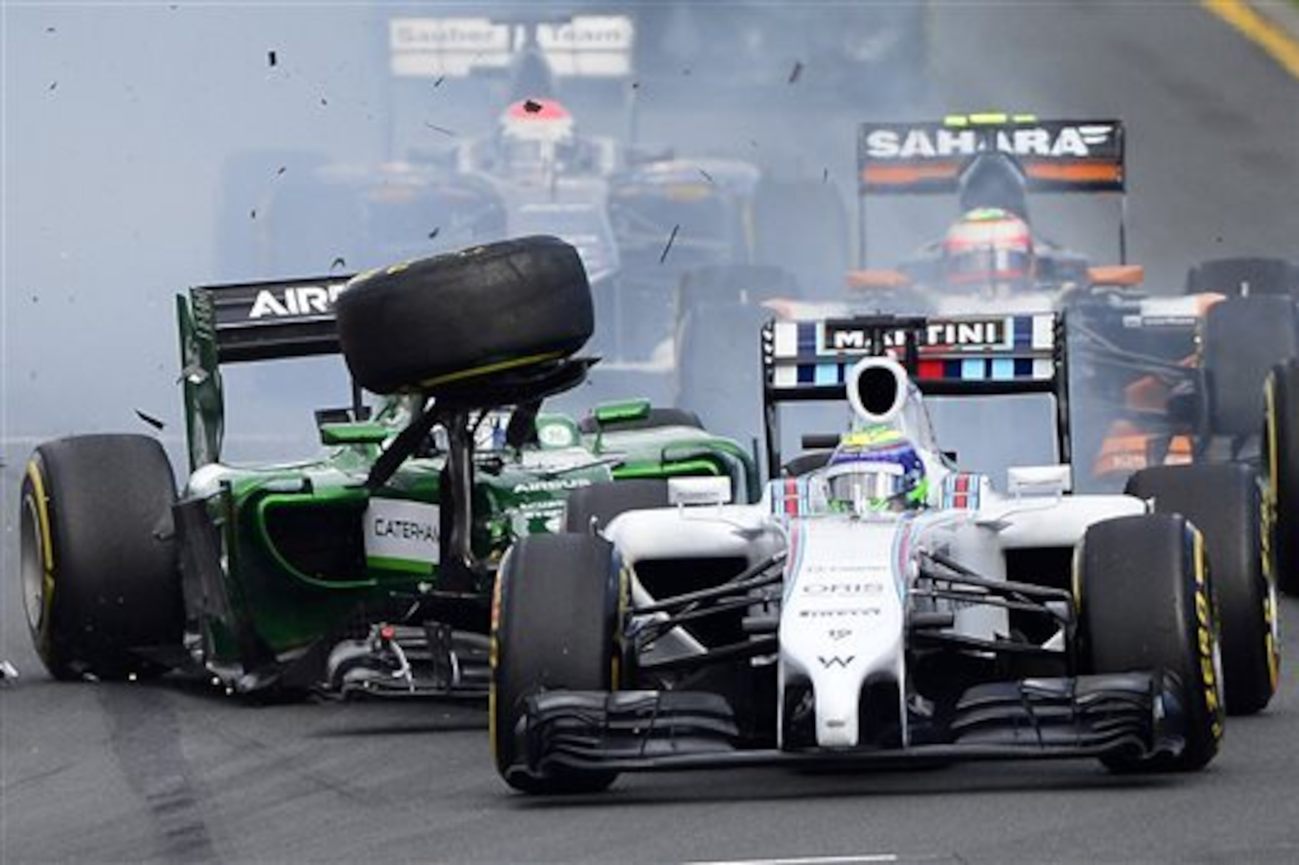 Caterham driver Kamui Kobayashi of Japan, left, collides with Williams driver Felipe Massa of Brazil at the start of the Australian Formula One Grand Prix at Albert Park in Melbourne, Australia, Sunday, March 16, 2014. Massa and Kobayashi walked away uninjured from the accident. (AP Photo/Ross Land)