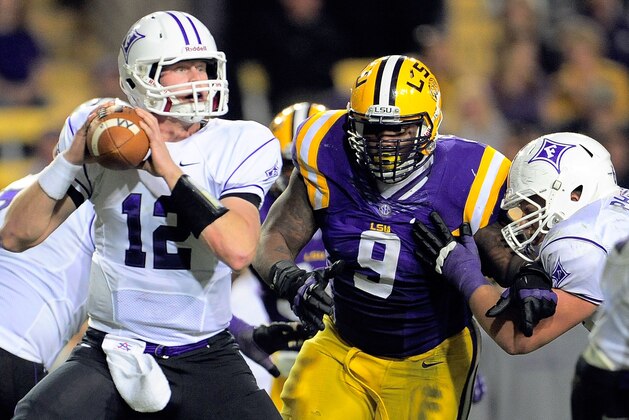 BATON ROUGE, LA - OCTOBER 26:  Reese Hannon #12 of the Furman Paladins is pressured by Ego Ferguson #9 of the LSU Tigers during a game at Tiger Stadium on October 26, 2013 in Baton Rouge, Louisiana.  LSU won the game 48-16.  (Photo by Stacy Revere/Getty Images)