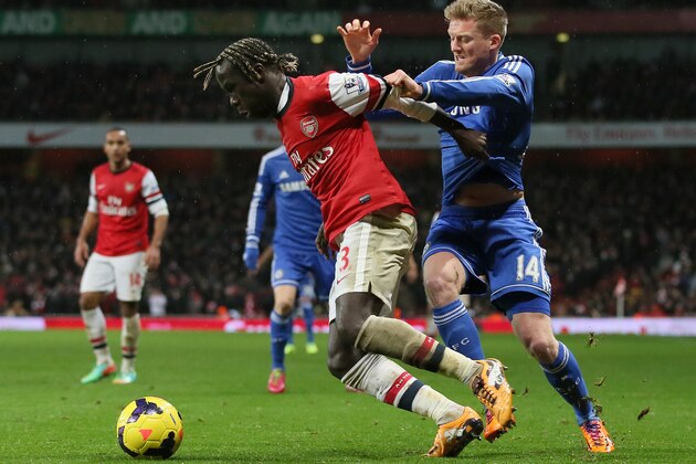 Arsenal's Bacary Sagna, left holds off the challenge of Chelsea's Andre Schuerrle during their English Premier League soccer match between Arsenal and Chelsea at the Emirates stadium in London, Monday, Dec. 23, 2013. (AP Photo/Alastair Grant)
