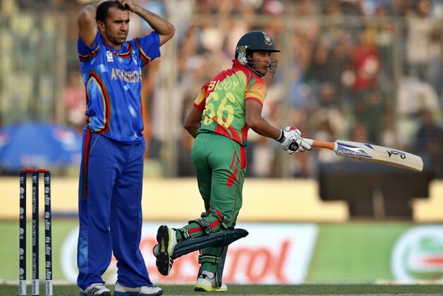 Afghanistan's bowler Karim Sadiq, left, reacts after Bangladesh's batsman Anamul Haque, right, hit a shot on his delivery during their ICC Twenty20 Cricket World Cup opening match in Dhaka, Bangladesh, Sunday, March 16, 2014. (AP Photo/Aijaz Rahi)