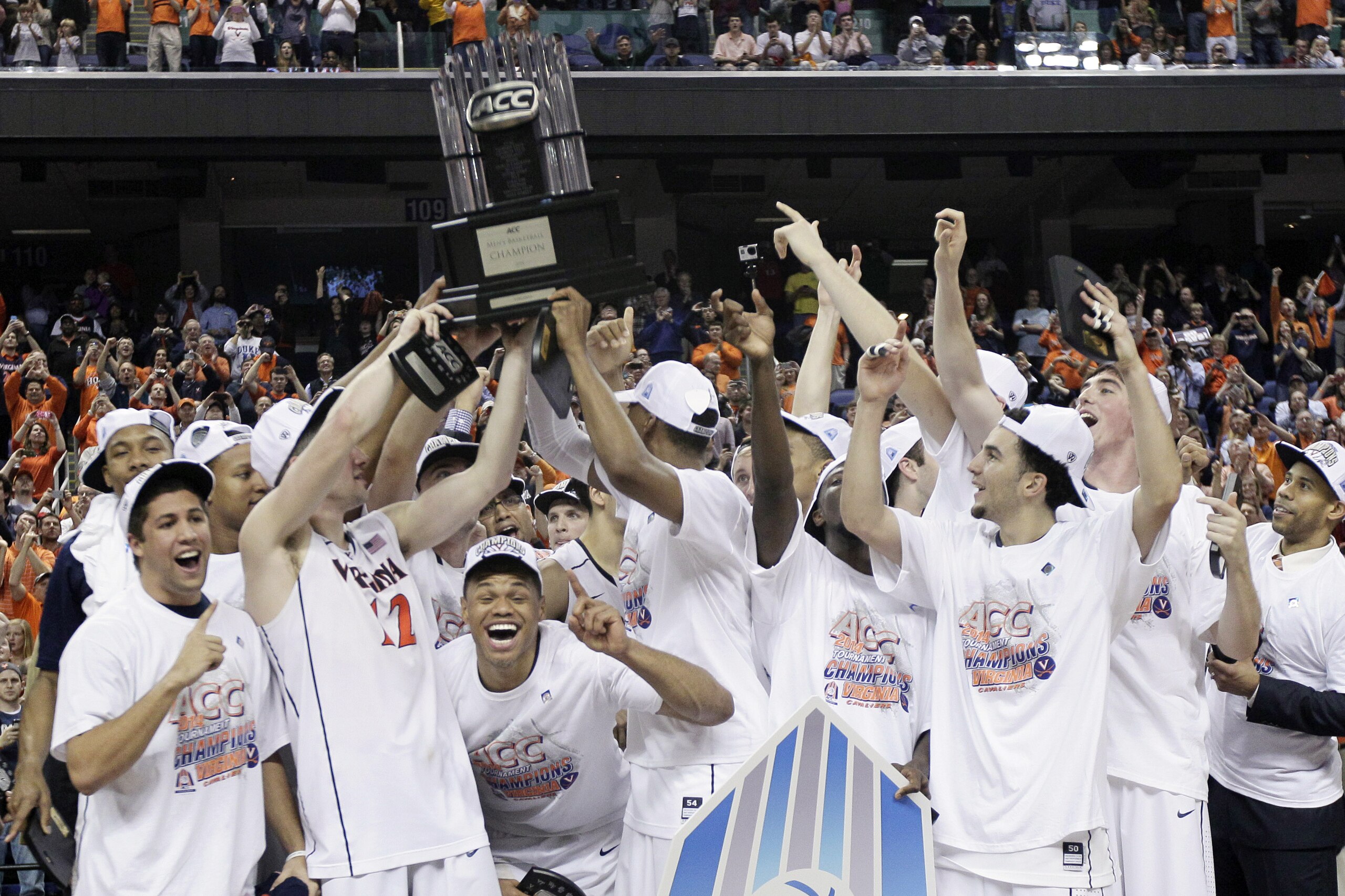 Virginia players celebrate with the trophy after defeating Duke in an NCAA college basketball game in the championship of the Atlantic Coast Conference tournament in Greensboro, N.C., Sunday, March 16, 2014. Virginia won 72-63. (AP Photo/Gerry Broome)