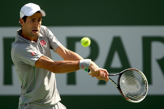 INDIAN WELLS, CA - MARCH 15:  Novak Djokovic of Serbia returns a shot to John Isner during the semifinals of the BNP Parabas Open at the Indian Wells Tennis Garden on March 15, 2014 in Indian Wells, California.  (Photo by Matthew Stockman/Getty Images)