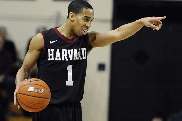 Harvard's Siyani Chambers, points and smiles at his team as he dribbles in the final seconds of an NCAA college basketball game against Yale, Friday, March 7, 2014, in New Haven, Conn. Harvard won 70-58. (AP Photo/Jessica Hill)