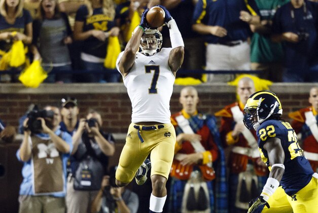Sep 7, 2013; Ann Arbor, MI, USA; Notre Dame Fighting Irish wide receiver TJ Jones (7) makes a catch while Michigan Wolverines safety Jarrod Wilson (22) goes in for the tackle in the first quarter at Michigan Stadium. Mandatory Credit: Rick Osentoski-USA TODAY Sports