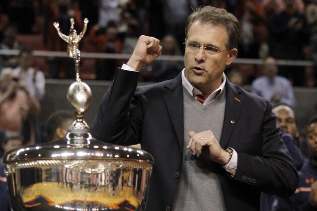 Auburn coach Gus Malzahn sings the Auburn fight song as he accepts the Foy-ODK Sportsmanship trophy during halftime of an NCAA college basketball game, Thursday, Jan. 30, 2014, in Auburn, Ala. (AP Photo/Butch Dill)