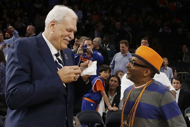 Former NBA coach Phil Jackson, left, and director Spike Lee, right, talk before a ceremony to honor the 1972-73 Championship New York Knicks team during the first half of an NBA basketball game between the Knicks and the Milwaukee Bucks, Friday, April 5, 2013, in New York. (AP Photo/Frank Franklin II)