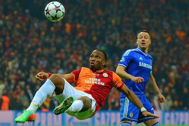 ISTANBUL, TURKEY - FEBRUARY 26:  John Terry of Chelsea looks on as Didier Drogba of Galatasaray clears the ball during the UEFA Champions League Round of 16 first leg match between Galatasaray AS and Chelsea at Ali Sami Yen Arena on February 26, 2014 in Istanbul, Turkey.  (Photo by Michael Regan/Getty Images)