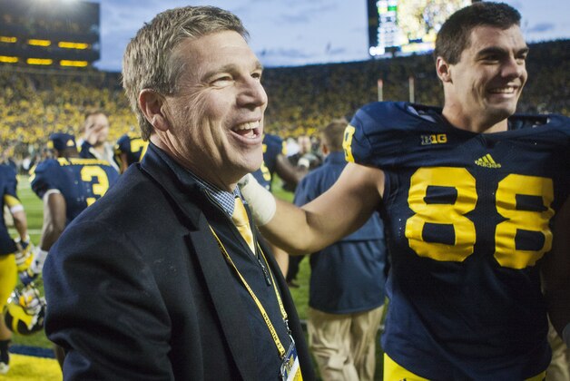 Michigan Athletic Director David Brandon, left, gives a hug to defensive end Craig Roh (88) as they celebrate after an NCAA college football game against Michigan State, Saturday, Oct. 20, 2012, in Ann Arbor, Mich. Michigan won 12-10. (AP Photo/Tony Ding)