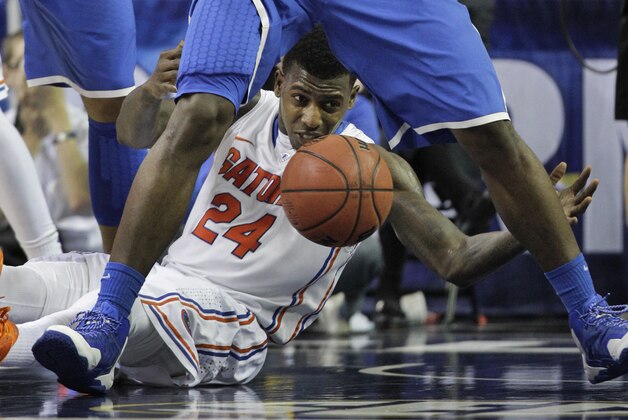 Florida forward Casey Prather (24) reaches for a loose ball in between the legs of Kentucky forward Alex Poythress (22) during the second half of an NCAA college basketball game in the Championship round of the Southeastern Conference men's tournament, Sunday, March 16, 2014, in Atlanta. (AP Photo/Steve Helber)