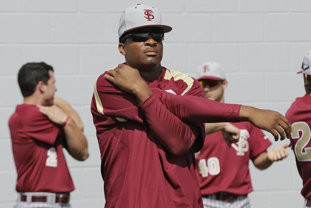 Florida State's Jameis Winston stretches before a spring training exhibition game against the New York Yankees Tuesday, Feb. 25, 2014, in Tampa, Fla. Winston is the 2013 Heisman Trophy winner. (AP Photo/Chris O'Meara)