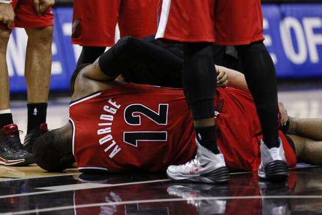 Mar 12, 2014; San Antonio, TX, USA; Portland Trail Blazers forward LaMarcus Aldridge (12) lays on the floor after being fouled by San Antonio Spurs forward Aron Baynes (not pictured) during the second half at AT&T Center. Mandatory Credit: Soobum Im-USA TODAY Sports